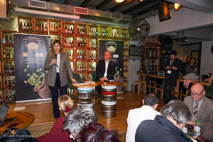 Greece on its Way to Develop and Promote Beer Tourism - Gastronomy Tours a woman speaks at a microphone - Gastronomy Tours